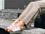 Quality European women's sandals. Made in Spain contoured cork footbed and rubber sole. Comfortable slide style sandal with triple buckles. Comes in white.
