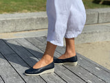 A person wearing a pair of navy Aerobics Lockheed 1 ballet shoes with a contoured insole and a lightweight rubber sole . Quality European women's footwear made from soft leathers.
