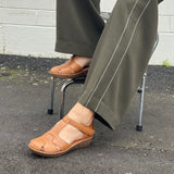 Smart tan sandal in soft leather uppers. Velcro strap, wedge sole unit with enclosed heel and enclosed toe. Comfortable T-bar style women's sandal. Women's shoes with cushioned footbed.